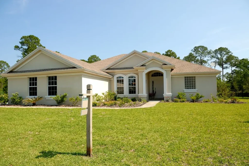 Single-story house with a manicured lawn on a sunny day.