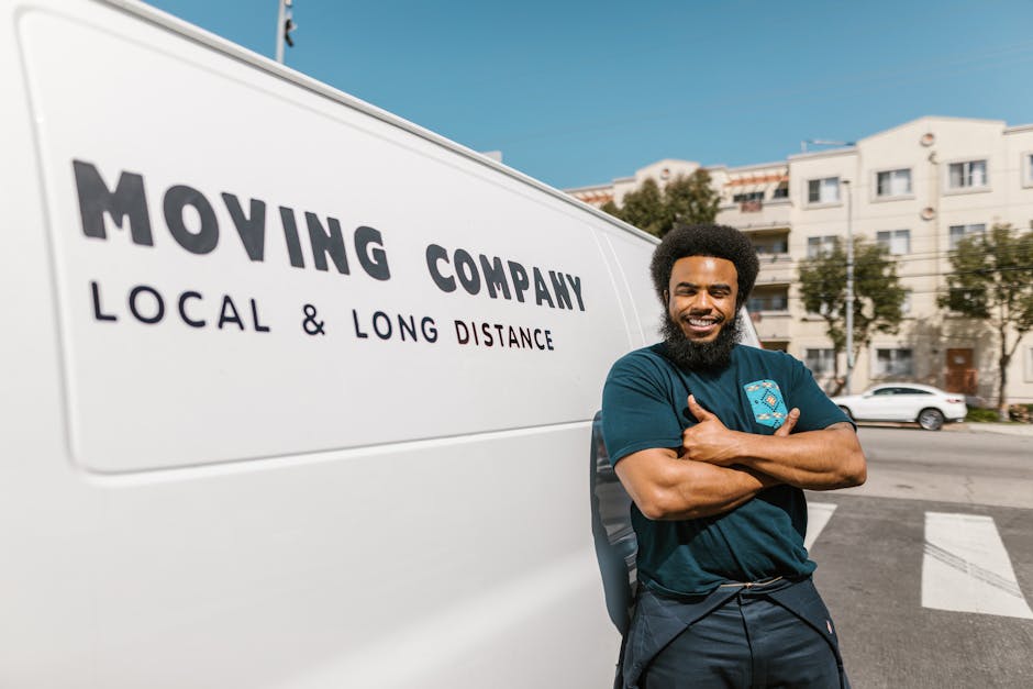 Confident mover standing next to a moving company van.