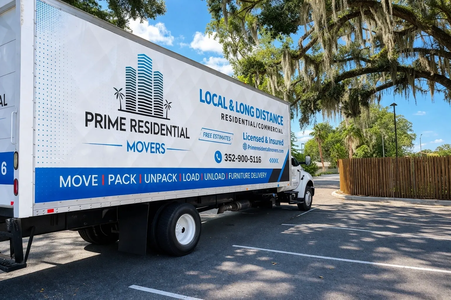 Moving truck parked under tree shade.